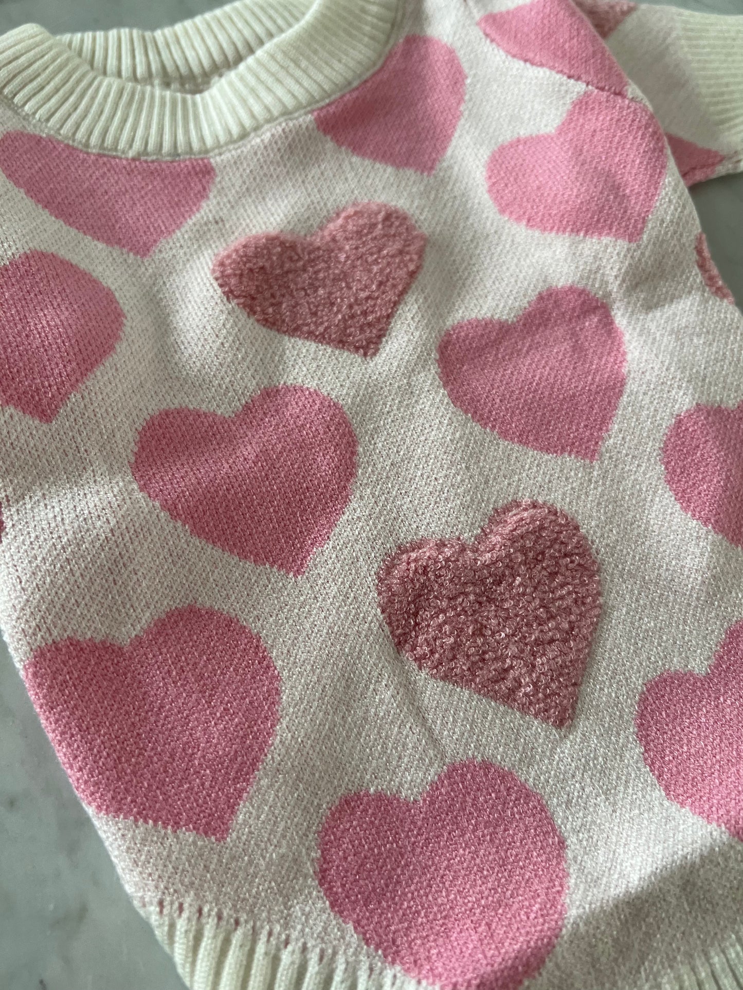 Suéter de punto corazones rosa